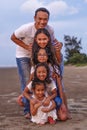 Happy Asian diversity generation family having fun together on tropical beach at summer. Smiling big family parents with children Royalty Free Stock Photo