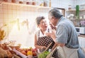 Happy asian elder senior couple cooking fresh meal in kitchen at home.Grandfather feed Grandmother with happy and laugh together Royalty Free Stock Photo