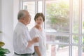 Happy asian elderly couple in love drinking milk togetherness at the living room. Healthy food concept