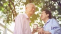 Happy Asian elderly couple morning walk in green city Royalty Free Stock Photo