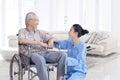 Happy Asian elderly man talking with nurse