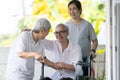 Happy asian elderly woman sit in wheelchair with female caregiver,senior grandmother greeting and welcoming visiting friend or her