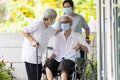 .Happy asian elderly woman wearing medical mask sit in wheelchair with female caregiver,best friend or her family visit to the Royalty Free Stock Photo