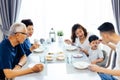 Happy Asian extended family having dinner at home full of laughter and happiness. Royalty Free Stock Photo