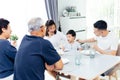 Happy Asian extended family having dinner at home full of laughter and happiness. Royalty Free Stock Photo