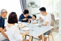 Happy Asian extended family having dinner at home full of laughter and happiness. Royalty Free Stock Photo