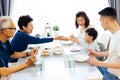 Happy Asian extended family having dinner at home full of laughter and happiness. Royalty Free Stock Photo