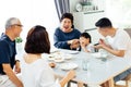 Happy Asian extended family having dinner at home full of laughter and happiness.