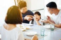 Happy Asian extended family having dinner at home full of laughter and happiness. Royalty Free Stock Photo