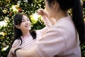 Happy asian family,beautiful woman and female teenage dancing around a decorated Christmas tree,celebrating Christmas eve,loving