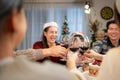 Happy asian family celebrating Christmas together at home. Cheerful senior parents and children in Santa hat Royalty Free Stock Photo