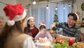 Happy asian family celebrating Christmas together at home. Cheerful senior parents and children in Santa hat Royalty Free Stock Photo