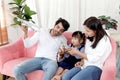 Happy Asian family. Chubby little girl daughter playing airplane toy with father and mother in living room. Kid and parents spend Royalty Free Stock Photo