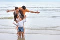 Happy asian family dad and mom with their children boy and girl raising hands with happy smiling face while standing on sandy Royalty Free Stock Photo