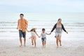 Happy asian family dad and mom with their children boy and girl running together with happy laughing face on sandy beach during Royalty Free Stock Photo
