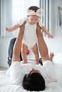 Happy asian family father with baby daughter playing on bed with Royalty Free Stock Photo