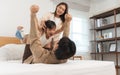 Happy Asian family, father, mother, cute daughter playing on bed in bedroom at home, bond and relax together. Little girl having Royalty Free Stock Photo