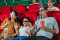 Asian family father, mother, daughter and grandmother watching movie at the cinema happily on weekends Royalty Free Stock Photo