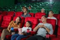 Happy Asian family of father, mother, daughter, and grandmother cherishes weekend moments at the cinema, sharing joy and Royalty Free Stock Photo