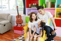 Happy asian family father, mother, and daughter sitting on sofa in colorful modern living room with relaxation and smiling face