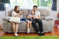 Happy Asian family, father, mother daughter and son singing karaoke on the sofa in the living room with happy smiling face Royalty Free Stock Photo