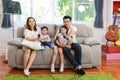 Happy Asian family, father, mother daughter and son singing karaoke on the sofa in the living room with happy smiling face Royalty Free Stock Photo