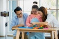 Happy Asian family father mother with a handicapped daughter with down syndrome play together. They are playing with a colorful