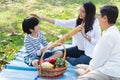 Happy Asian family has leisure or picnic in the park on the weekend or holiday. Grandmother, daughter and grandson are in beautifu