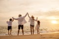 Happy Asian family have fun jumping together on beach in holiday at sunset time Royalty Free Stock Photo