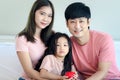 Happy Asian family having fun in bedroom. Father, mother and daughter girl hugging each other to show warm love, mom and dad, Royalty Free Stock Photo