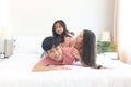 Happy Asian family having fun in bedroom. Father, mother and daughter playing together during lying on white bed. Parents having Royalty Free Stock Photo