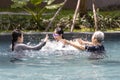 Happy asian family having fun in swimming pool in summer vacation,mother and daughter playing with her senior grandmother is enjoy Royalty Free Stock Photo