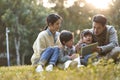 Happy asian family having a good time outdoors in city park Royalty Free Stock Photo