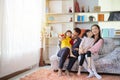 Happy Asian family hugging and cuddling with two little daughters, sitting on cozy sofa at home Royalty Free Stock Photo