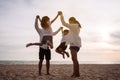 Happy asian family jumping together on the beach in holiday vacation. Silhouette of the family holding hands enjoying the sunset Royalty Free Stock Photo