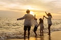 Happy asian family jumping together on the beach in holiday vacation. Silhouette of the family holding hands enjoying the sunset Royalty Free Stock Photo