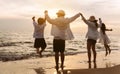 Happy asian family jumping together on the beach in holiday vacation. Silhouette of the family holding hands enjoying the sunset Royalty Free Stock Photo