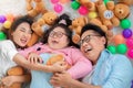 Happy Asian family laying on carpet in living room and smile with their daughter down syndrome child , a lot color balls and teddy Royalty Free Stock Photo