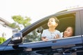 Happy Asian family is looking up in the sky and travelling on the road trip, going for a drive for vacation. Royalty Free Stock Photo