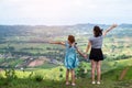 Happy asian family mother and daughter standing on top of beautiful mountain holding raised hands Royalty Free Stock Photo