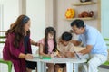 Happy Asian family with mother father daughter and son draw together in living room at home for they education when spend their Royalty Free Stock Photo