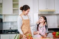 Happy Asian family. Mother and kid preparing healthy food and having fun in kitchen at home Royalty Free Stock Photo