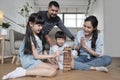 Happy Asian family, parents, and kids are playing with wooden blocks together Royalty Free Stock Photo