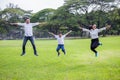 happy asian Family, parents and their children jumping together in park . father mother and son having fun and laughing outdoors Royalty Free Stock Photo