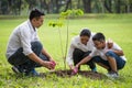 happy asian Family, parents and their children plant sapling tree together in park . father mother and son,boy having fun and Royalty Free Stock Photo