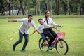 happy asian Family, parents and their children riding bike in park together. father pushes  mother and son on bicycle having fun Royalty Free Stock Photo