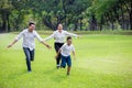 happy asian Family, parents and their children running around  in park together. father mother and son having fun and laughing Royalty Free Stock Photo