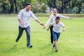 happy asian Family, parents and their children running around  in park together. father mother and son having fun and laughing Royalty Free Stock Photo