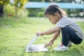 Happy asian family picnic. Daughters playing mobile phones and laptops having fun together while sitting alone on sunny day Royalty Free Stock Photo