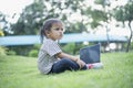 Happy asian family picnic. Daughters playing mobile phones and laptops having fun together while sitting alone on sunny day Royalty Free Stock Photo